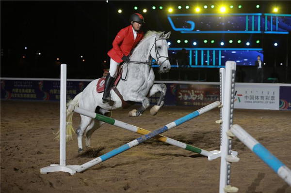 A member of the Inner Mongolia Equestrian Team jumps an obstacle on horseback during the opening ceremony of the Fifth International Equestrian Festival in Hohhot, Inner Mongolia autonomous region on Sept 21.jpg