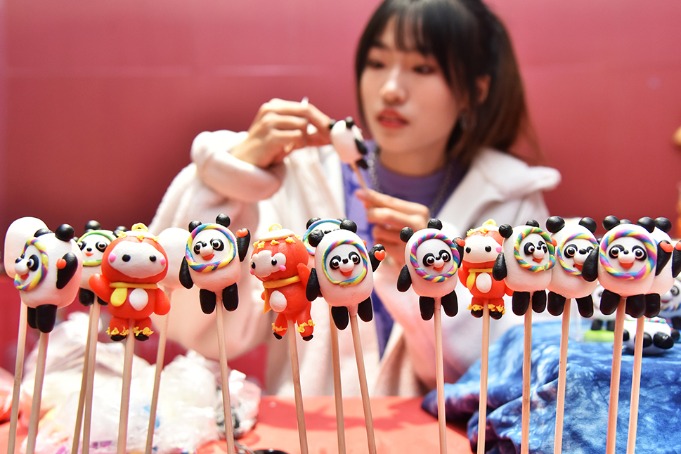 Young female inheritor makes dough dolls of Bing Dwen Dwen